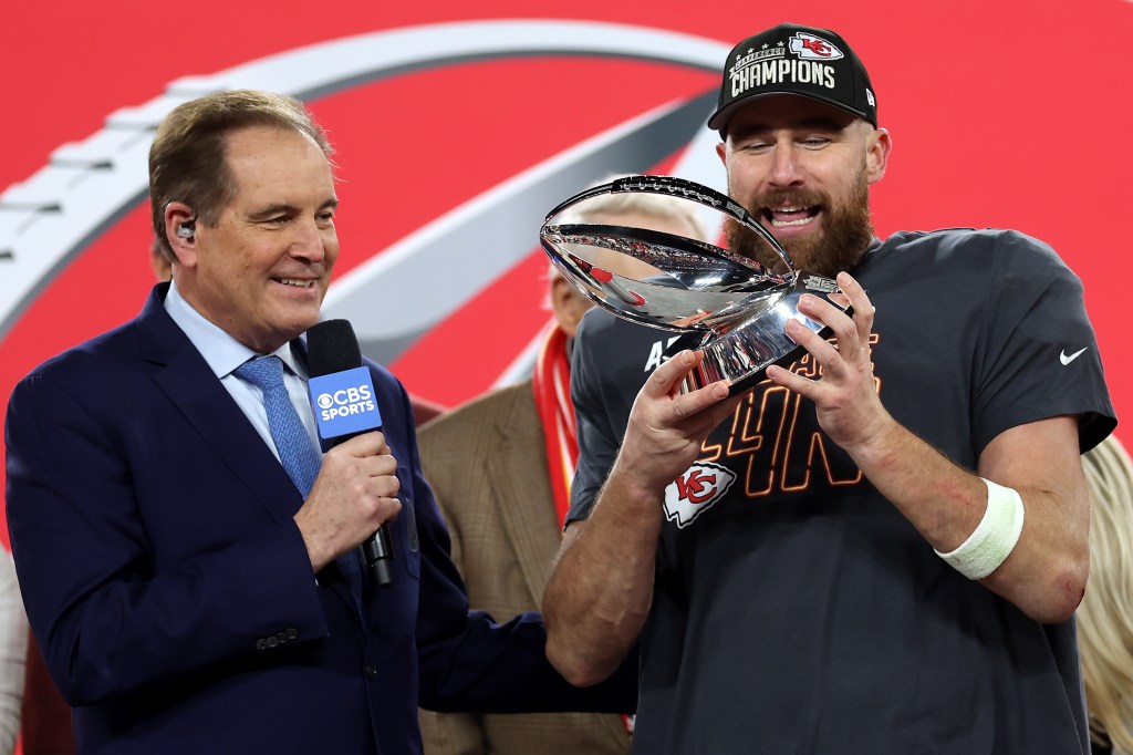 Travis Kelce holds the Lamar Hunt Trophy.